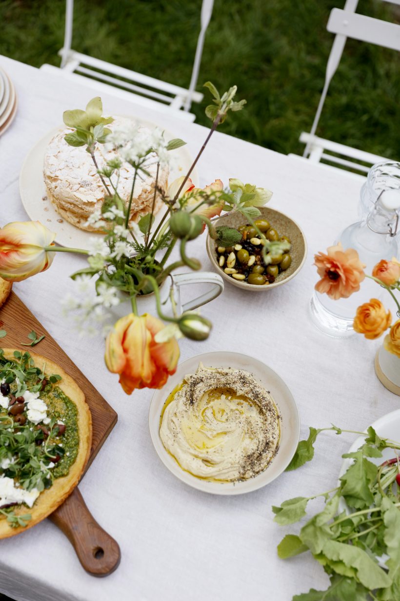 spring tablesetting for an outdoor party, flowers, tulips, hummus