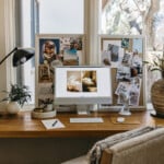 Modern desk with silver monitor in front of two vision boards.