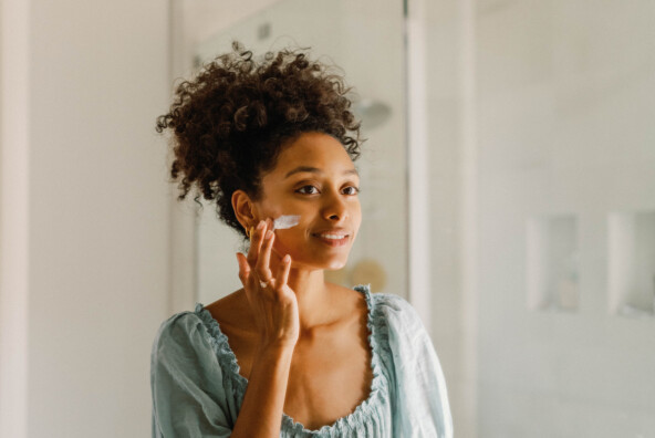 Woman applying face lotion