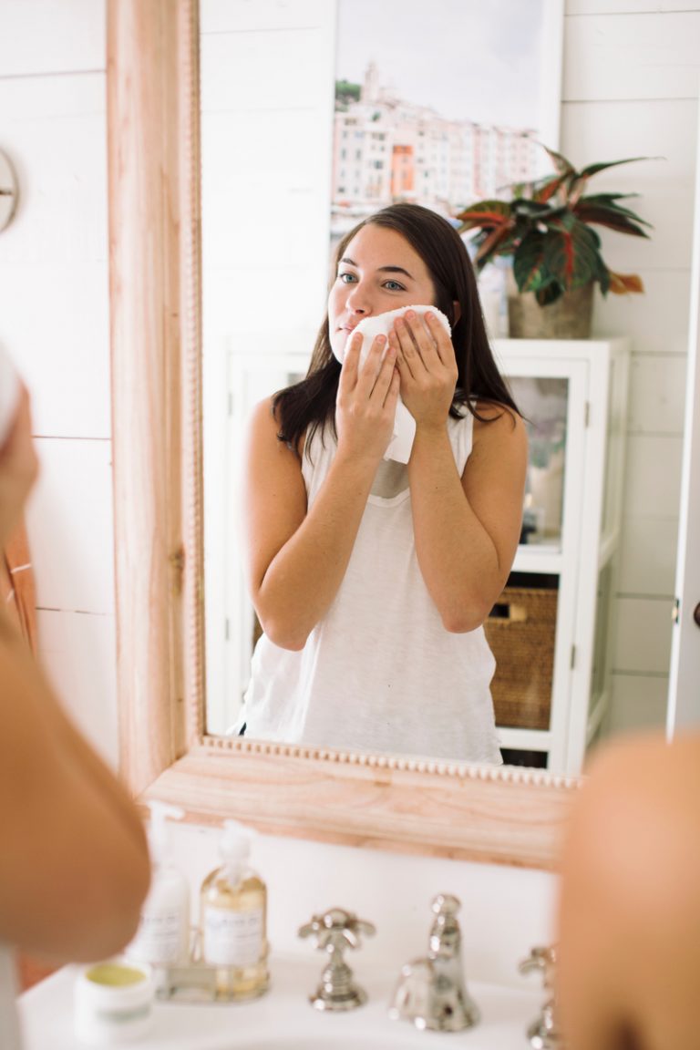 woman washing face in the mirror_how to minimize pores