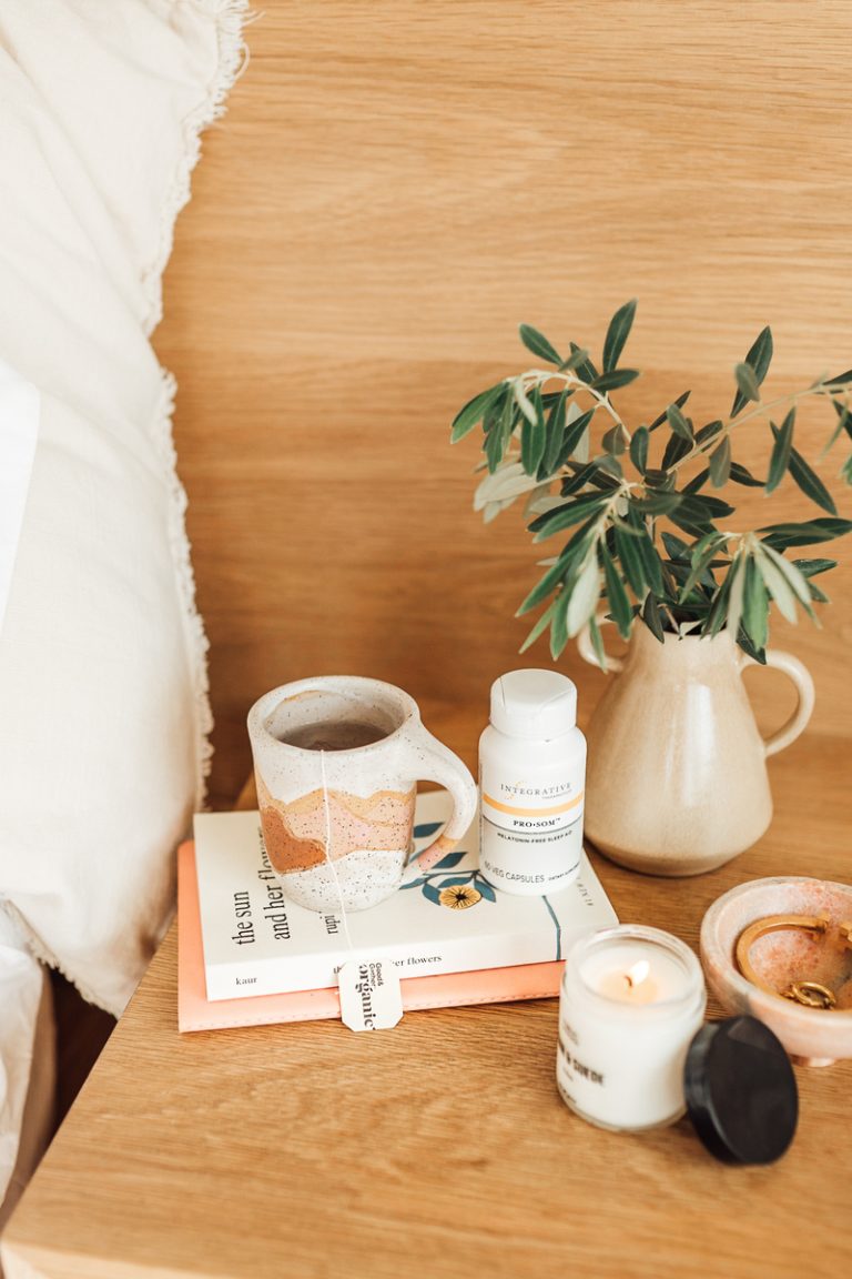 supplement on the bedside table with tea and a vase with greenery_ birth control and vitamin deficiency