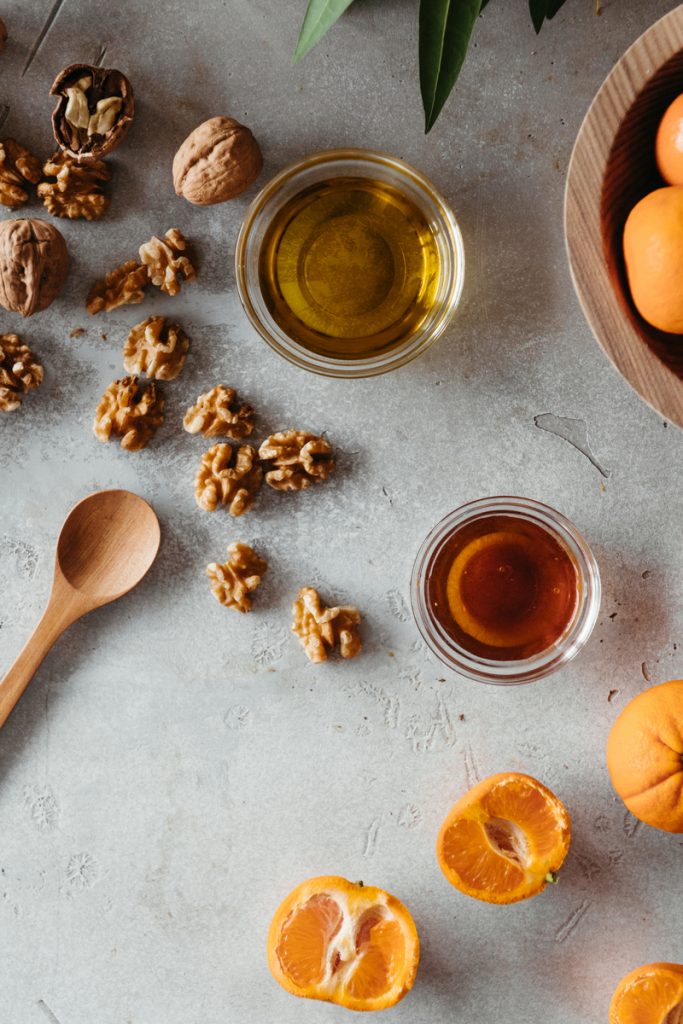 Flat lay of walnuts, oil, and citrus