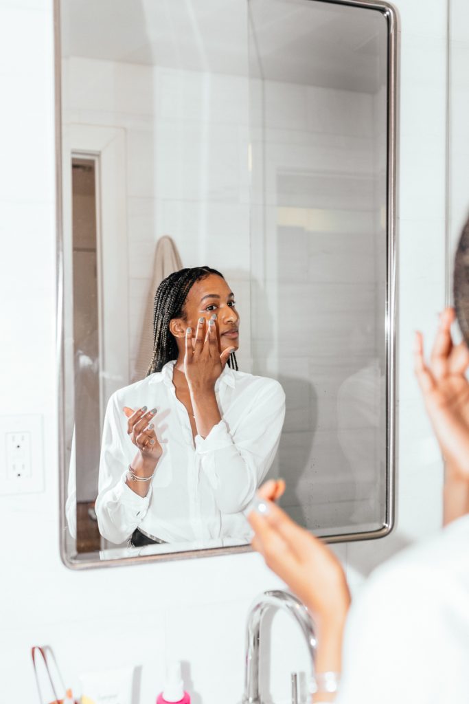 Shanika Hillocks applying skincare in mirror_best way to apply skincare