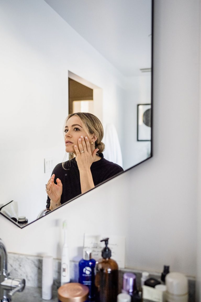 femme blonde appliquant des soins de la peau dans un miroir_meilleure façon d'appliquer des soins de la peau