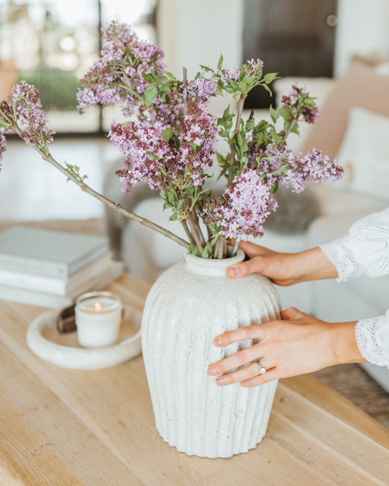 Camille Styles placing a bouquet of flowers on the coffee table_small acts of kindness ideas