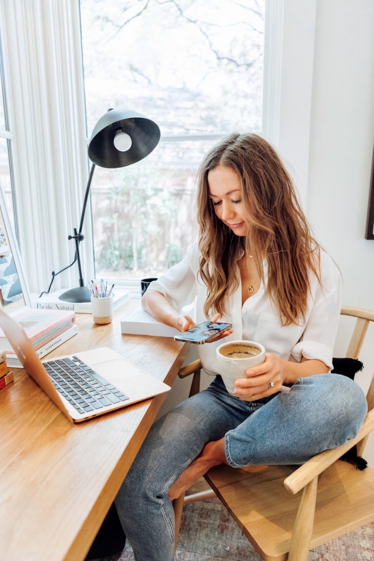 Camille Styles on phone at desk_internal shower drink