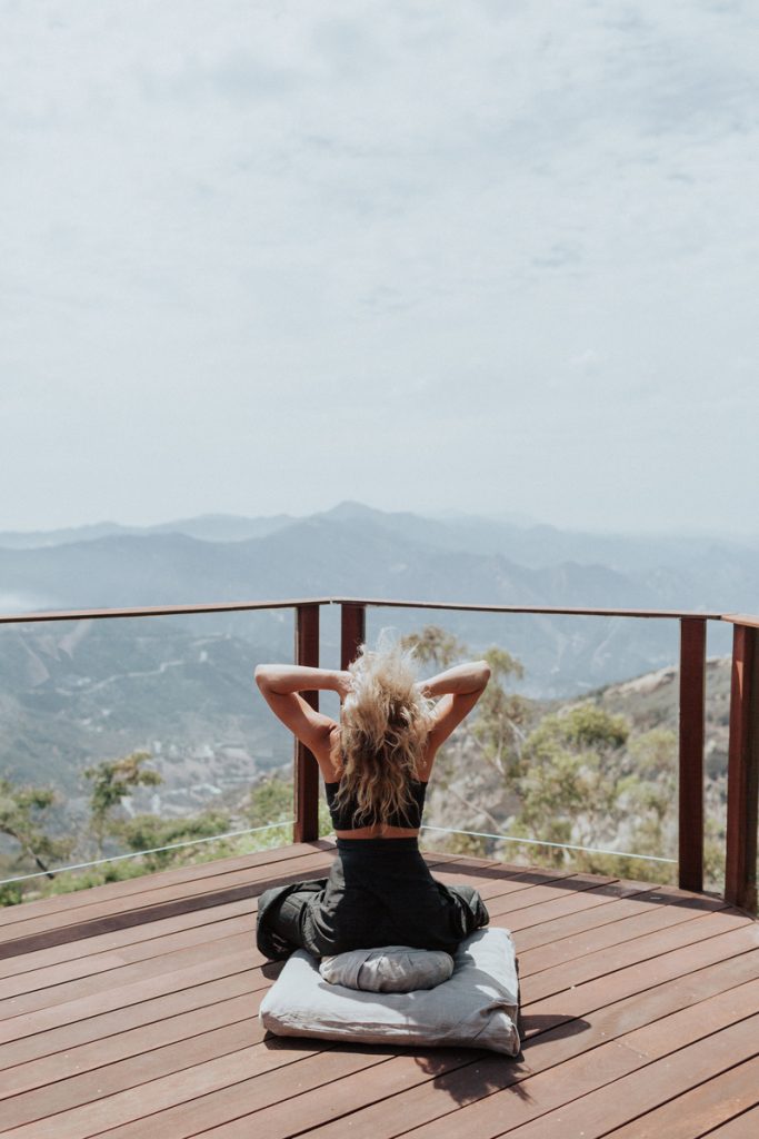 Nitsa Citrine stretching on deck in her Malibu home_natural remedies for fatigue