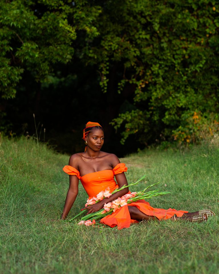 Paola Mathé sitting in the field holding snapdragons_ how gut health affects your period