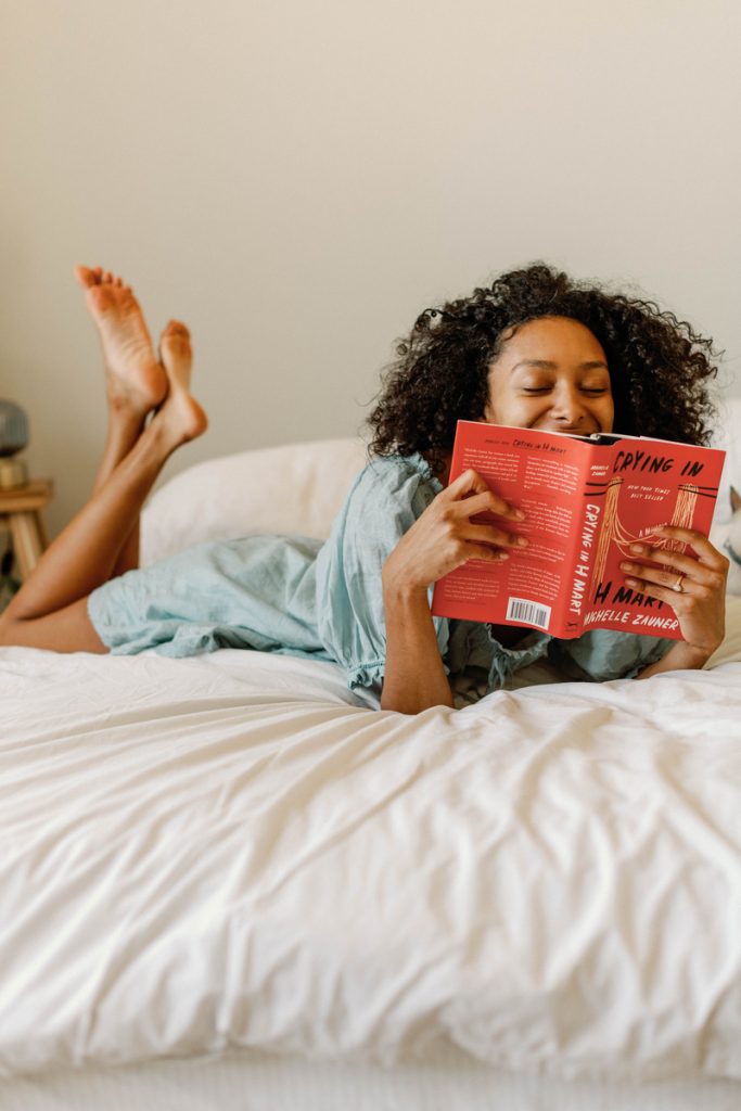 Woman reading a book on bed.