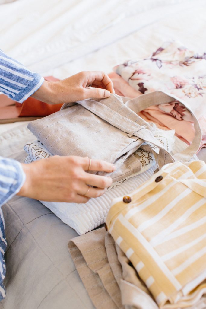 woman folding laundry on bed_best nontoxic laundry detergents