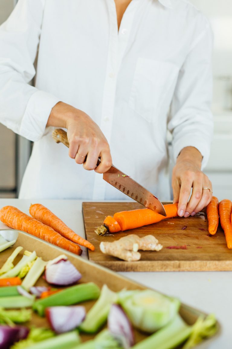 woman chopping carrots for bone broth_foods rich in collagen