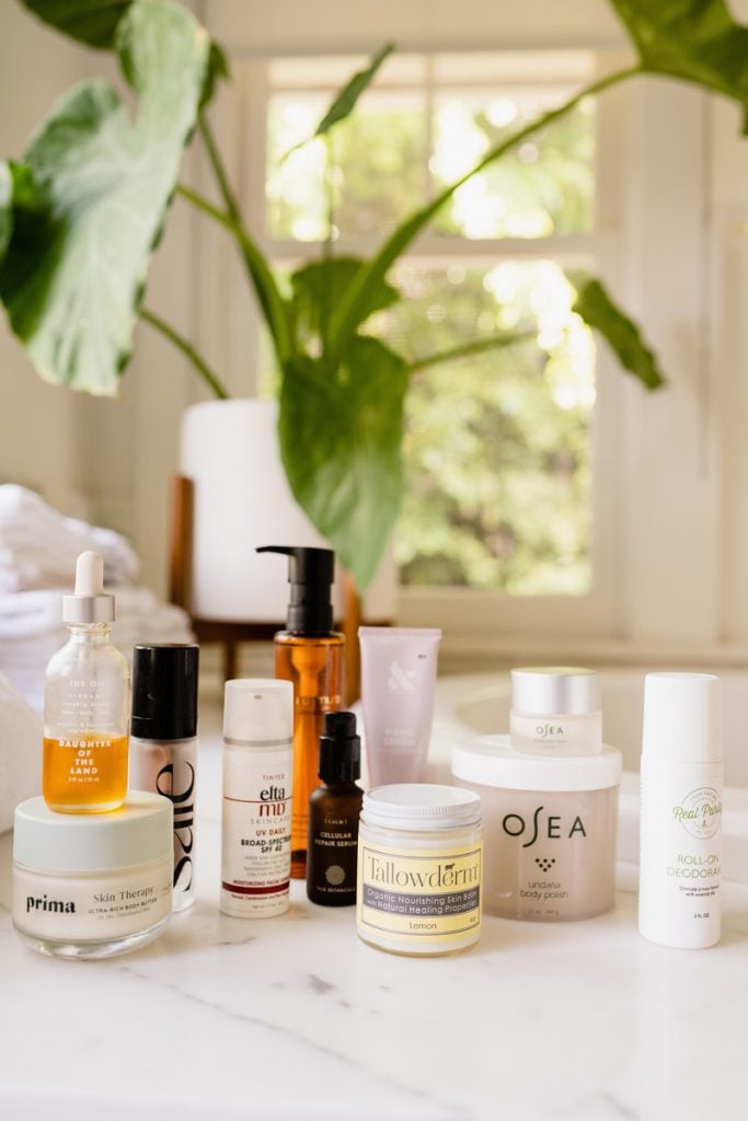 Various skincare products on a white marble counter.