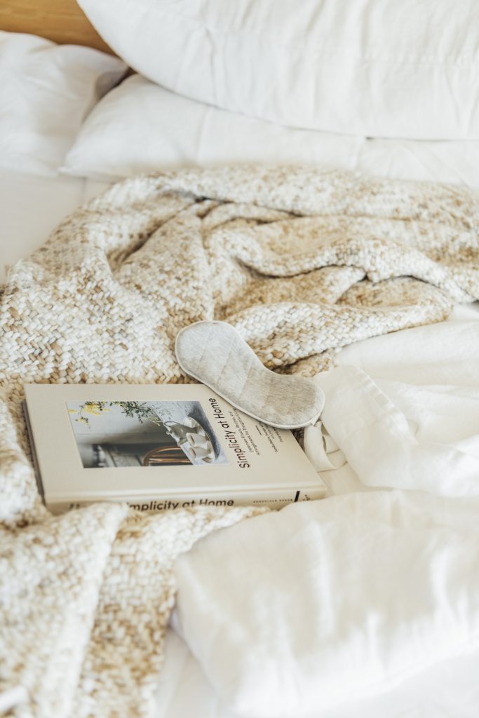 cozy bed with book and eye mask_summer to fall transition tips