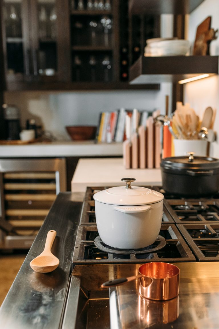 White enamel small Le Creuset Dutch oven on stovetop.