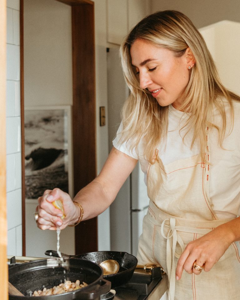 Woman cooking at stovetop.