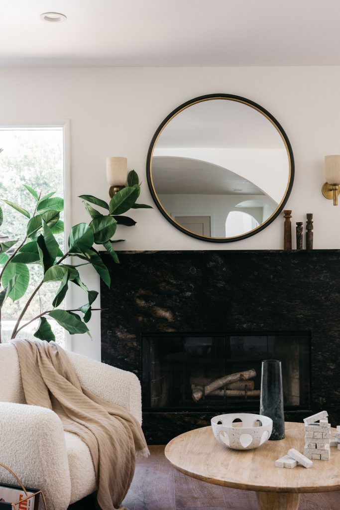 black fireplace in white living room with plant