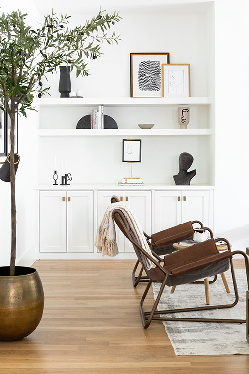 White living room with leather accent chairs