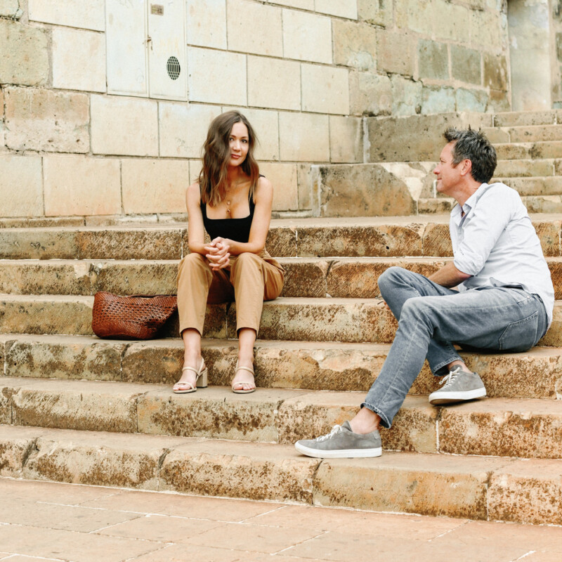 Woman and man sitting on outdoor steps in Oaxaca, Mexico.
