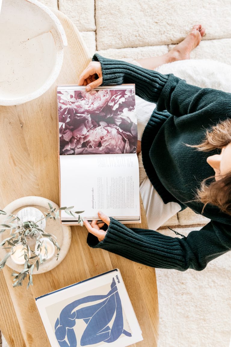 Camille Styles is reading at the coffee table