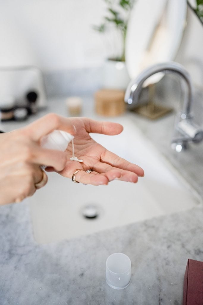 woman pouring cleanser into hand