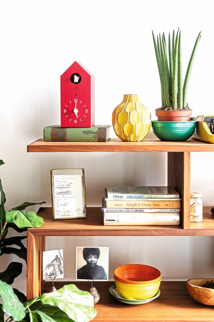 Eclectic bookshelf with photos and art.