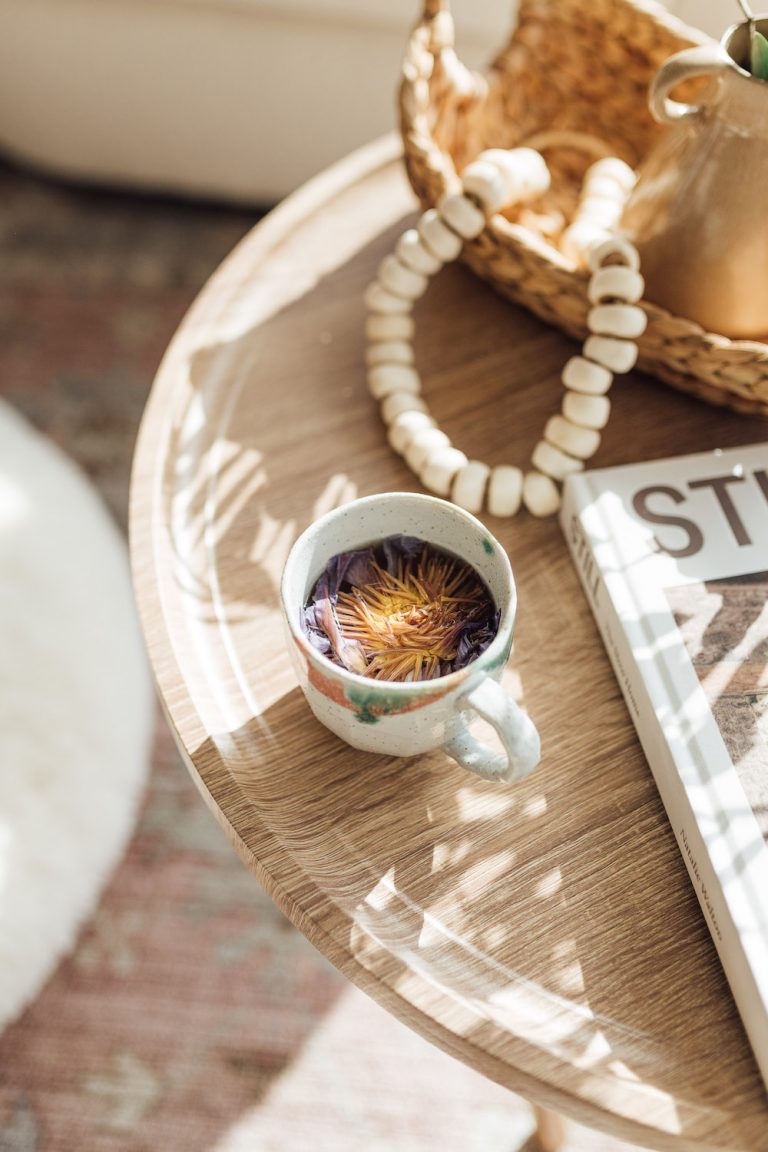 Cup of floral tea on wood coffee table.