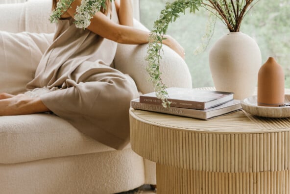 Woman sitting next to flowers on coffee table thinking about stress and libido.