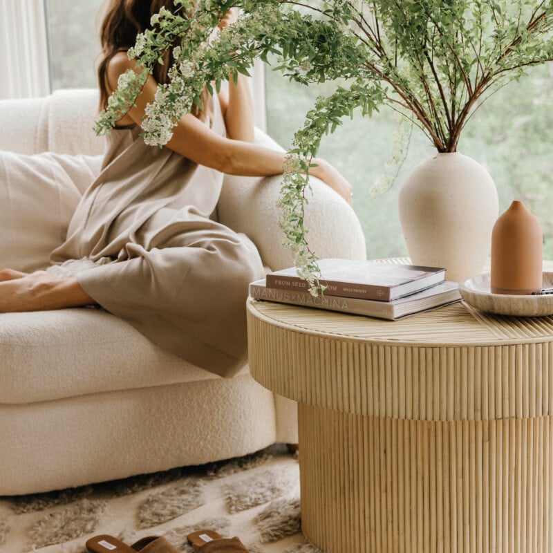 Woman sitting next to flowers on coffee table thinking about stress and libido.