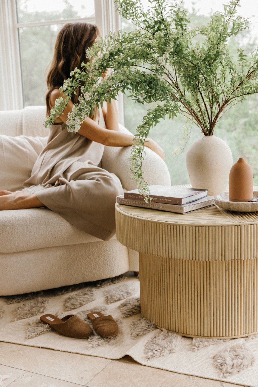 Woman sitting next to flowers on coffee table thinking about stress and libido.