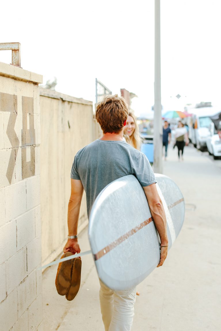 man carrying surfboard_gifts for significant other
