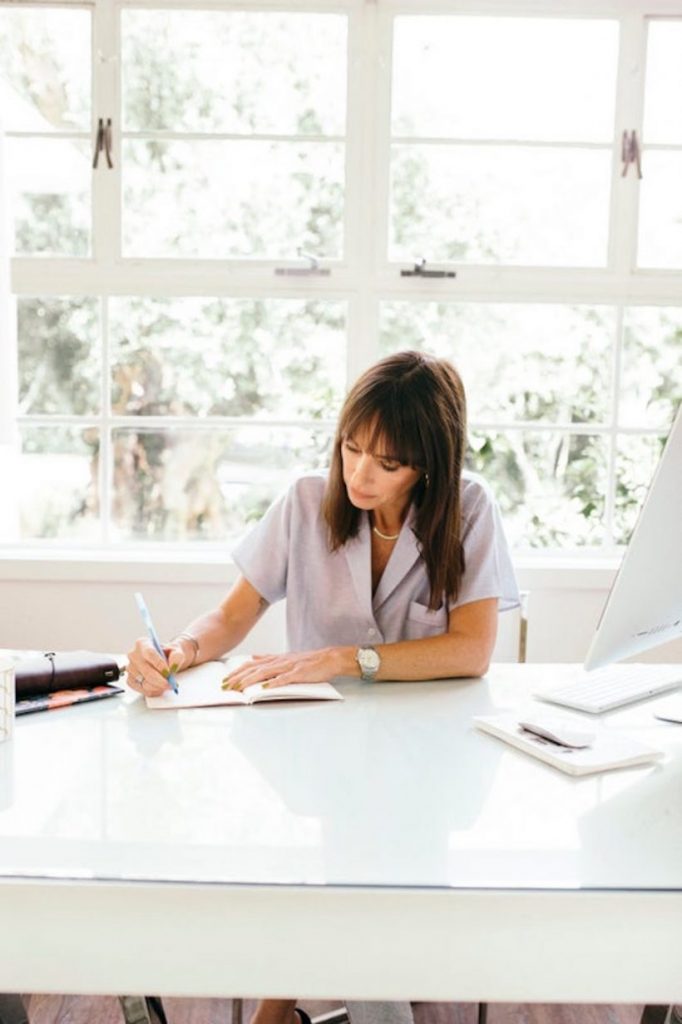 Catt Sadler writing at desk.