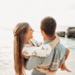 man holding woman on beach