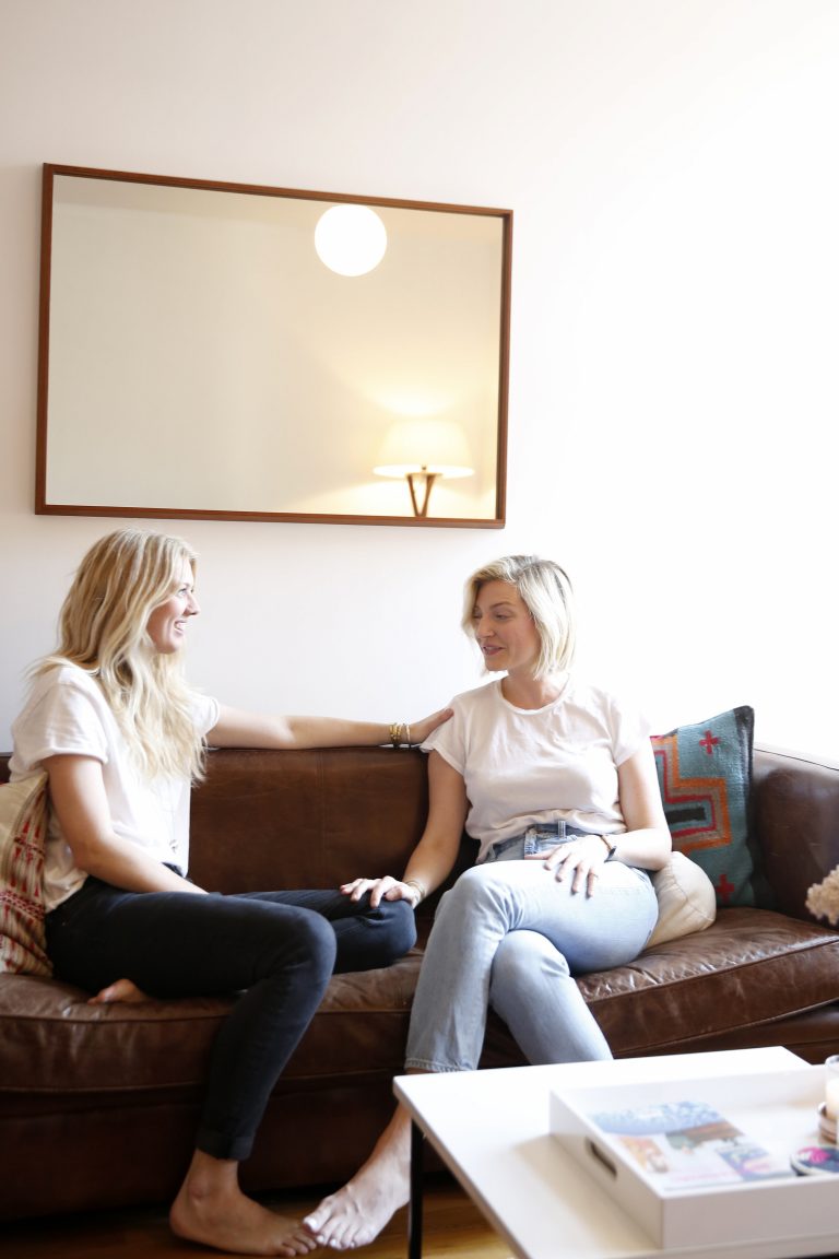 Two women are sitting on the sofa. 