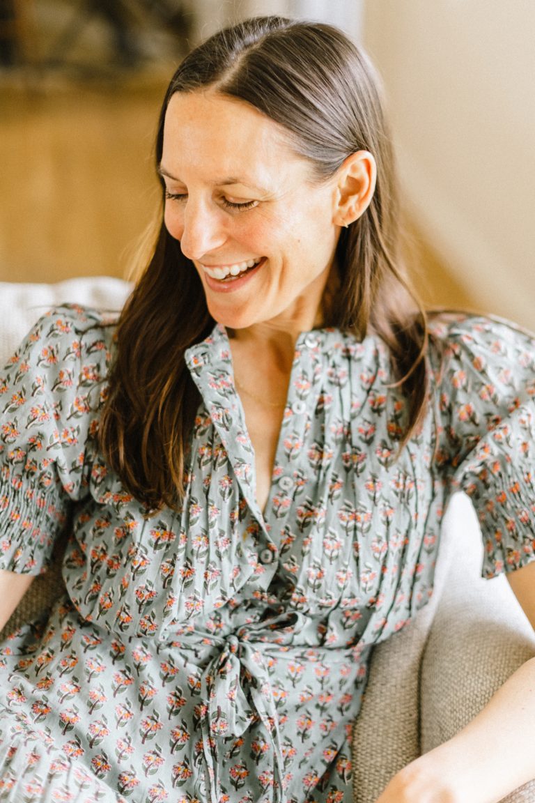 Woman smiling on couch.