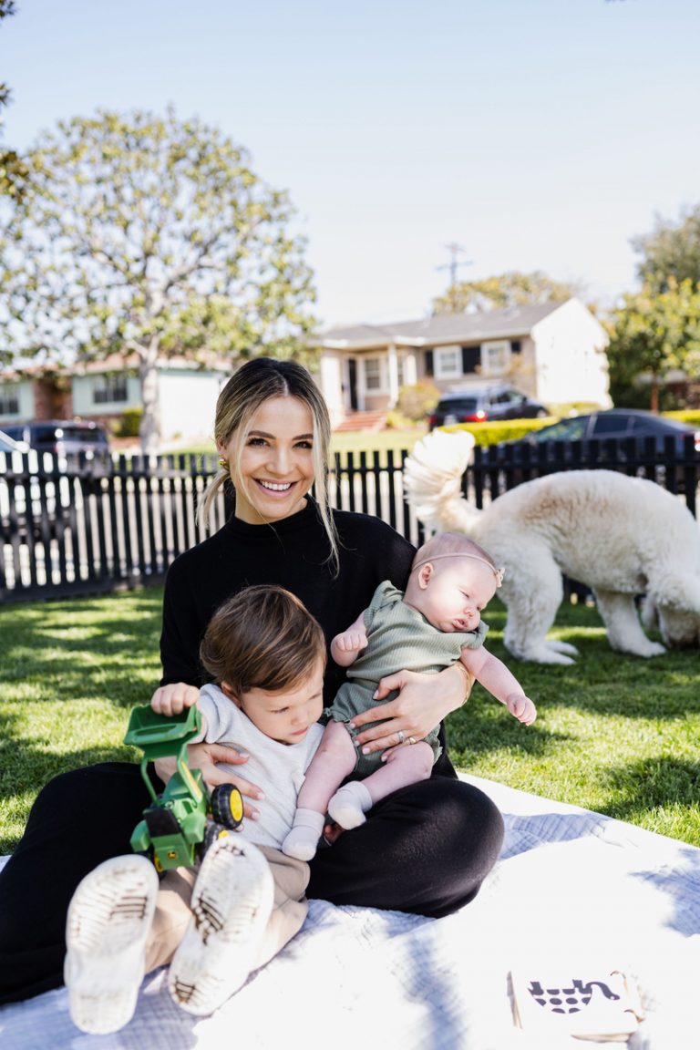 Woman playing with toddler, baby and dog outside