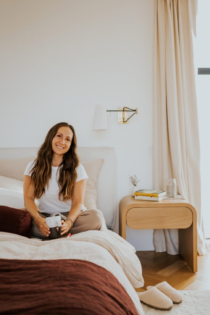 woman sitting on bed drinking tea winter hair care tips