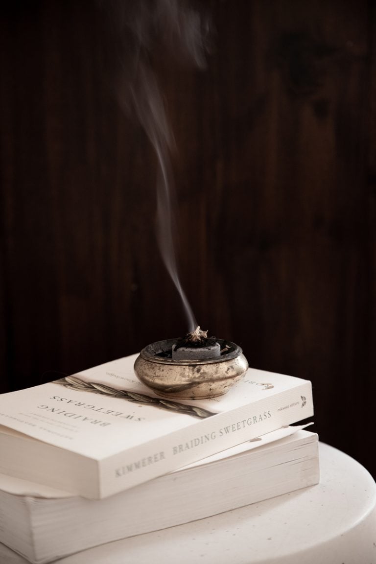 stack of books with incense manifestation techniques