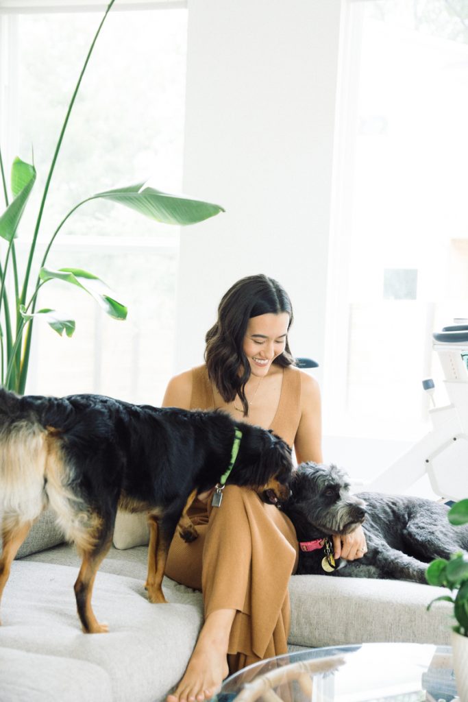 woman playing with dogs on couch breast screening for under 40s