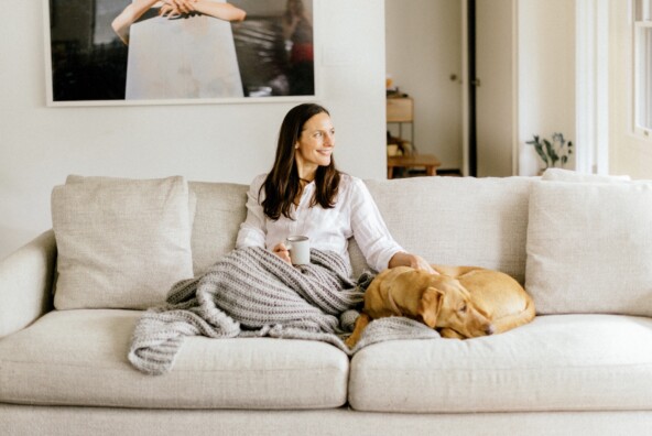 woman sitting on couch with dog