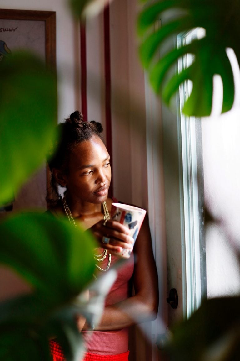 Woman looking out the window surrounded by plant growth concept