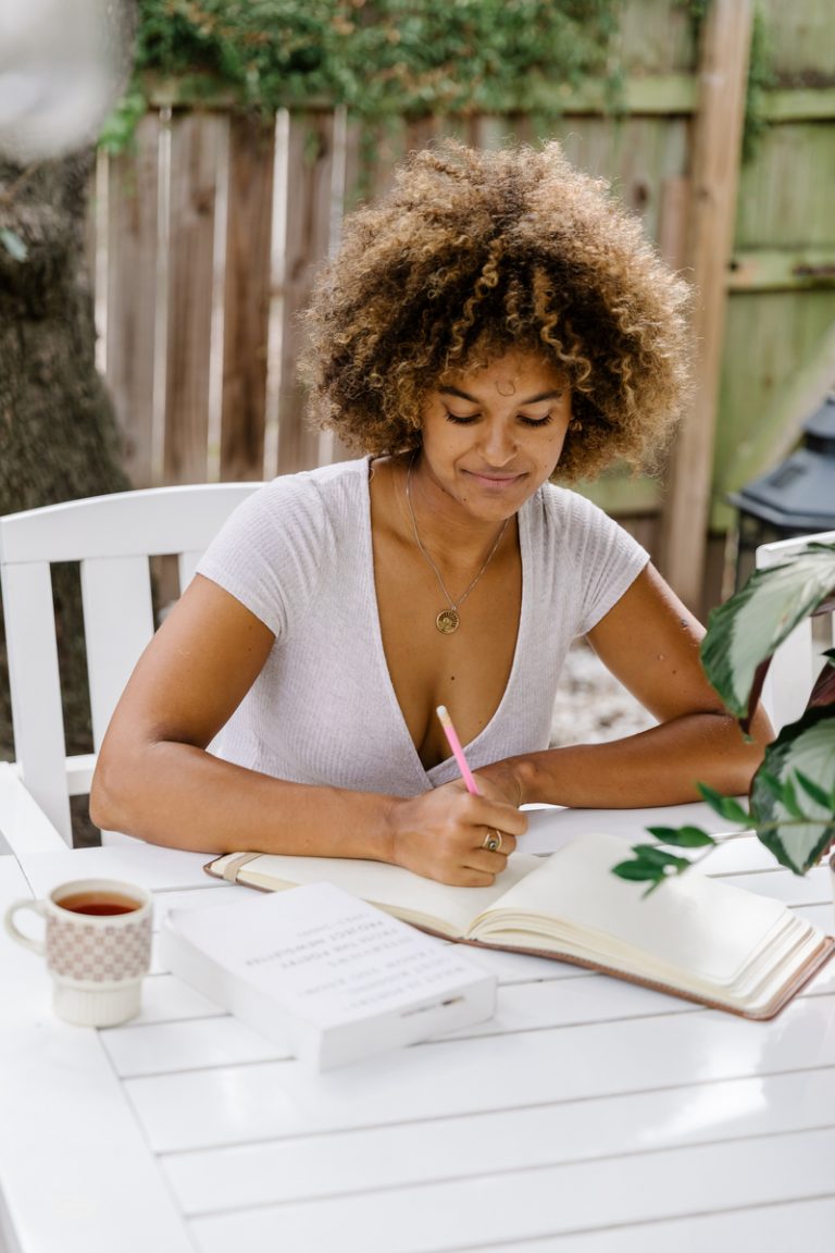 woman journaling outside breast screening for under 40s