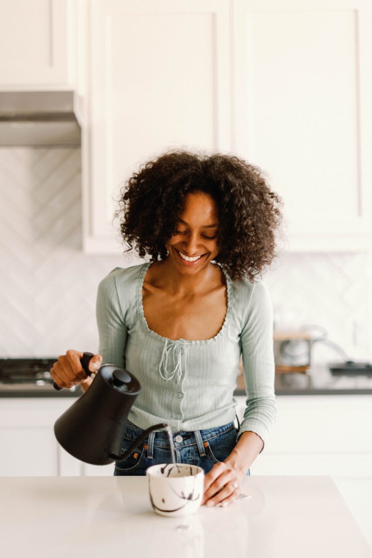 woman pouring tea in kitchen manifestation techniques