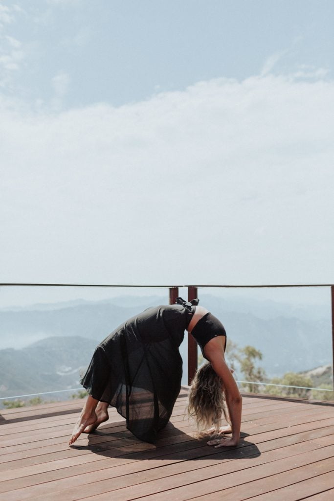 woman doing yoga on porch outside