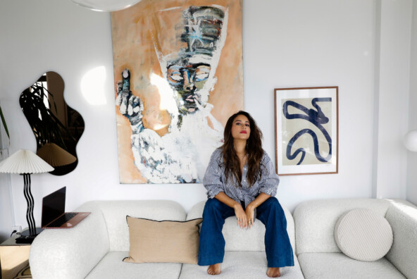 Woman sitting on couch in stylish, modern living room.