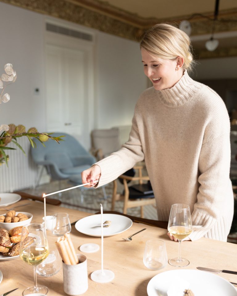 woman lighting candles dining table what fruits and vegetables are in season in winter