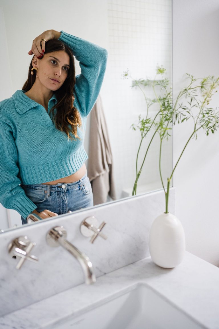 woman washing face in mirror, how to improve skin texture