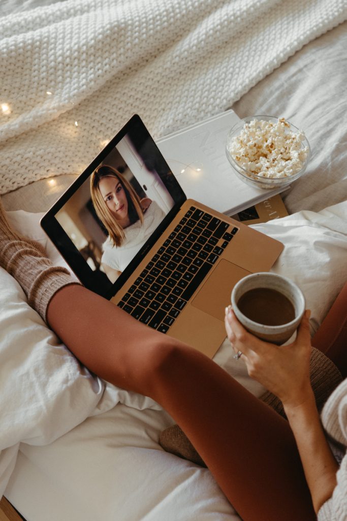 woman watching movie on laptop in bed family movie night ideas