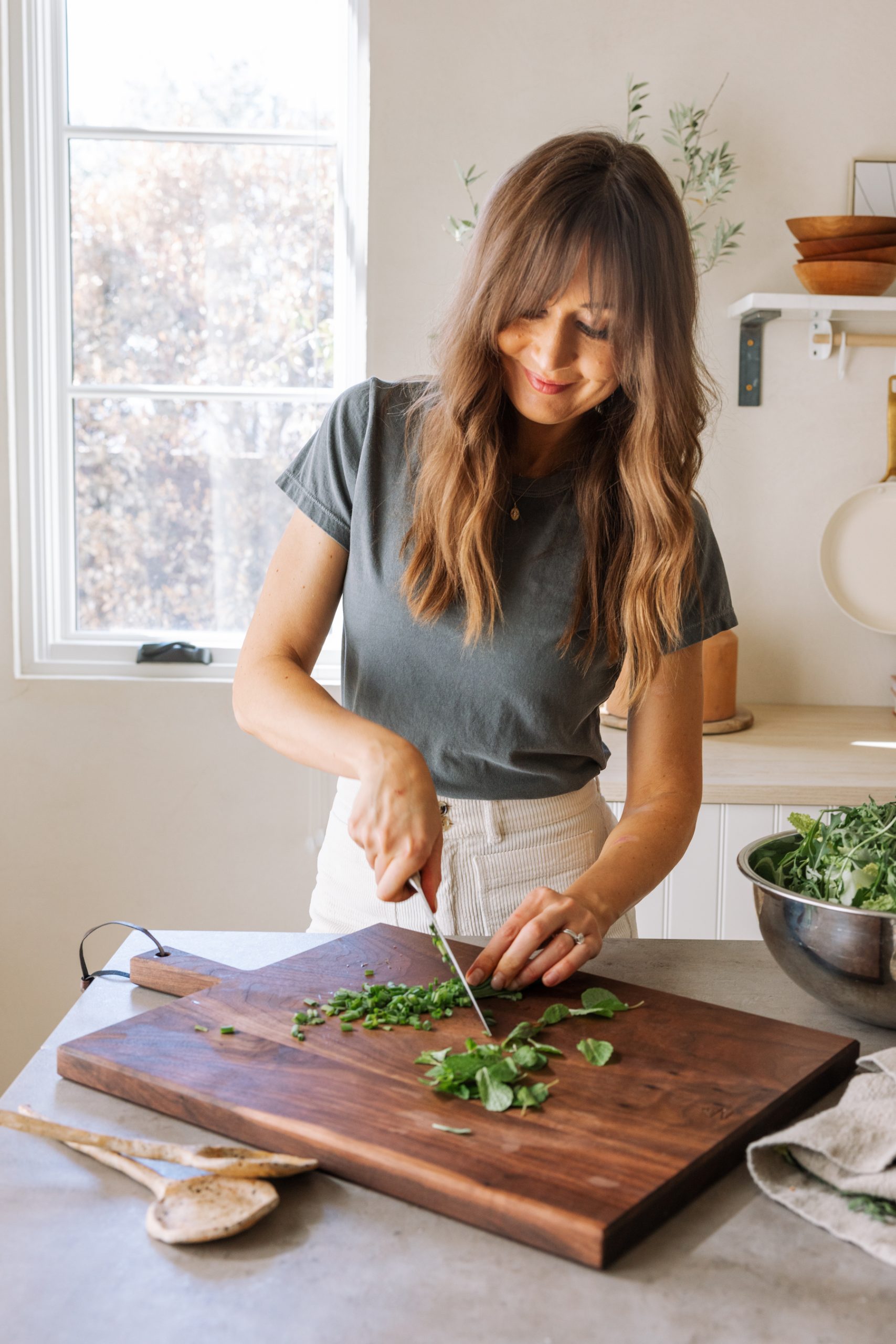 camille chopping herbs, fresh spring produce, greens, meal prep, kitchen, casa zuma gathering board