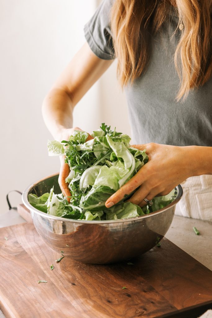 camille cooking, mixing lettuce, simple green salad recipe with vinaigrette, inspired by via carota's insalata verde