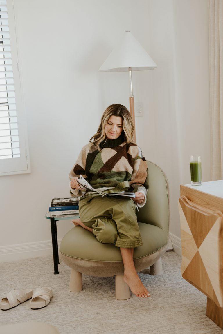 woman reading on chair with green smoothie